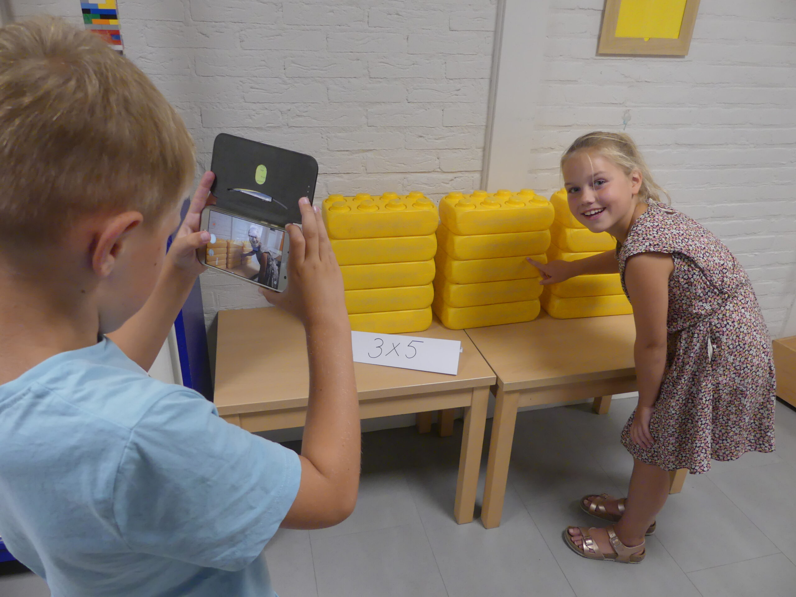 2 kinderen die een foto maken van 3 x 5 blokken